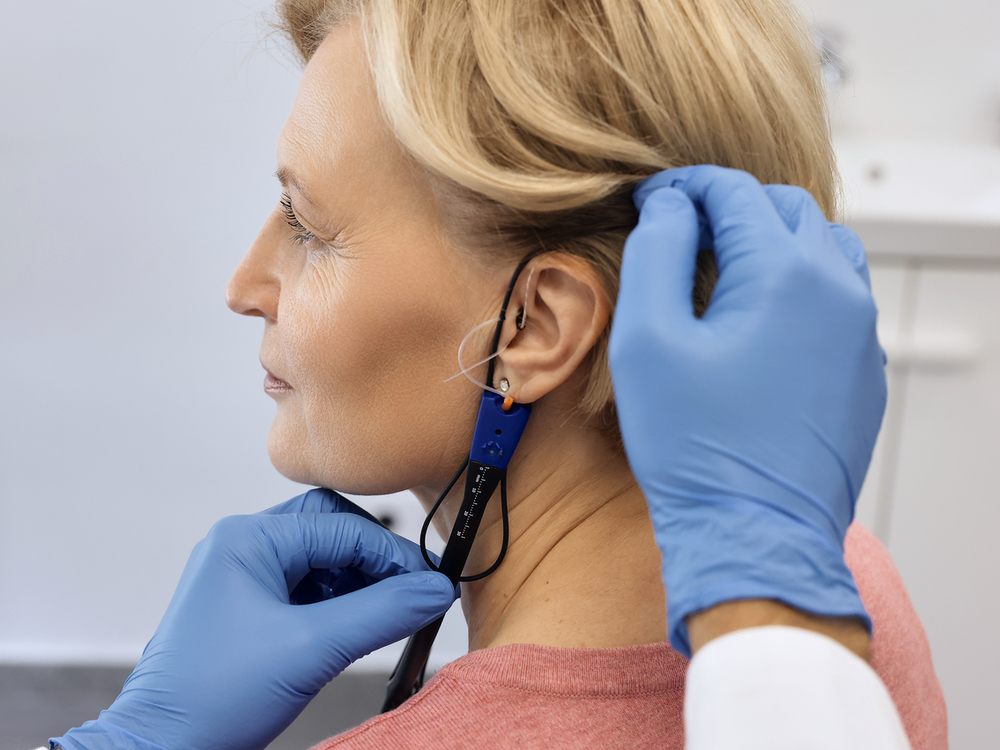 Doctor of Audiology performing real ear measurement with a probe microphone on a hearing aid patient at AFA Balance & Hearing Institute in Mesa, AZ